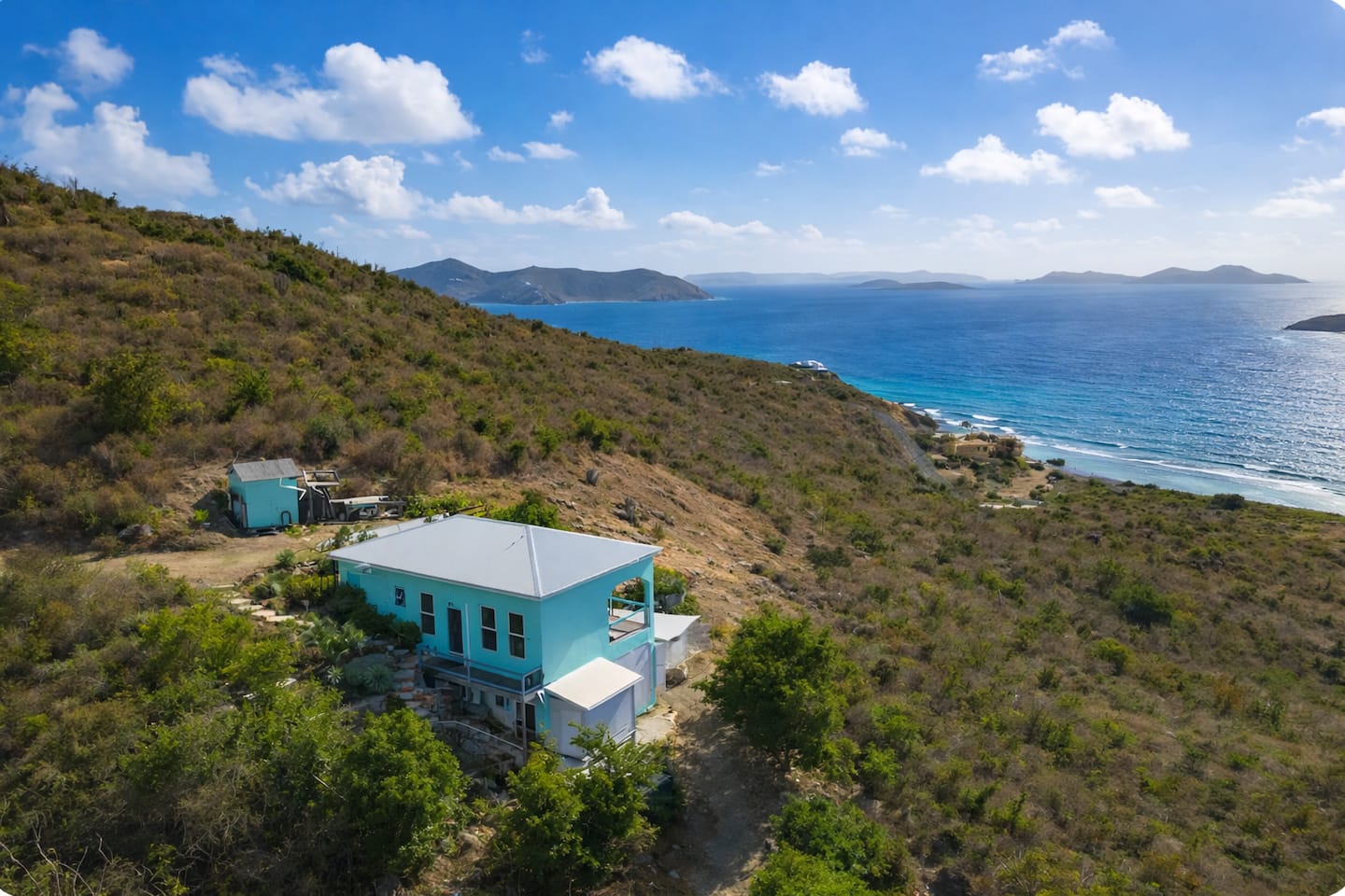 Aerial view of Surf Sound Cottage on the hillside above the sea