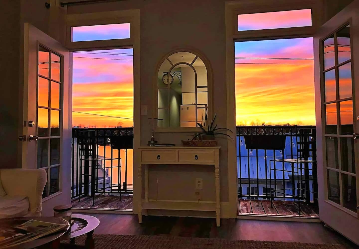 Colorful sunset viewed through the open balcony doors of the downtown condo