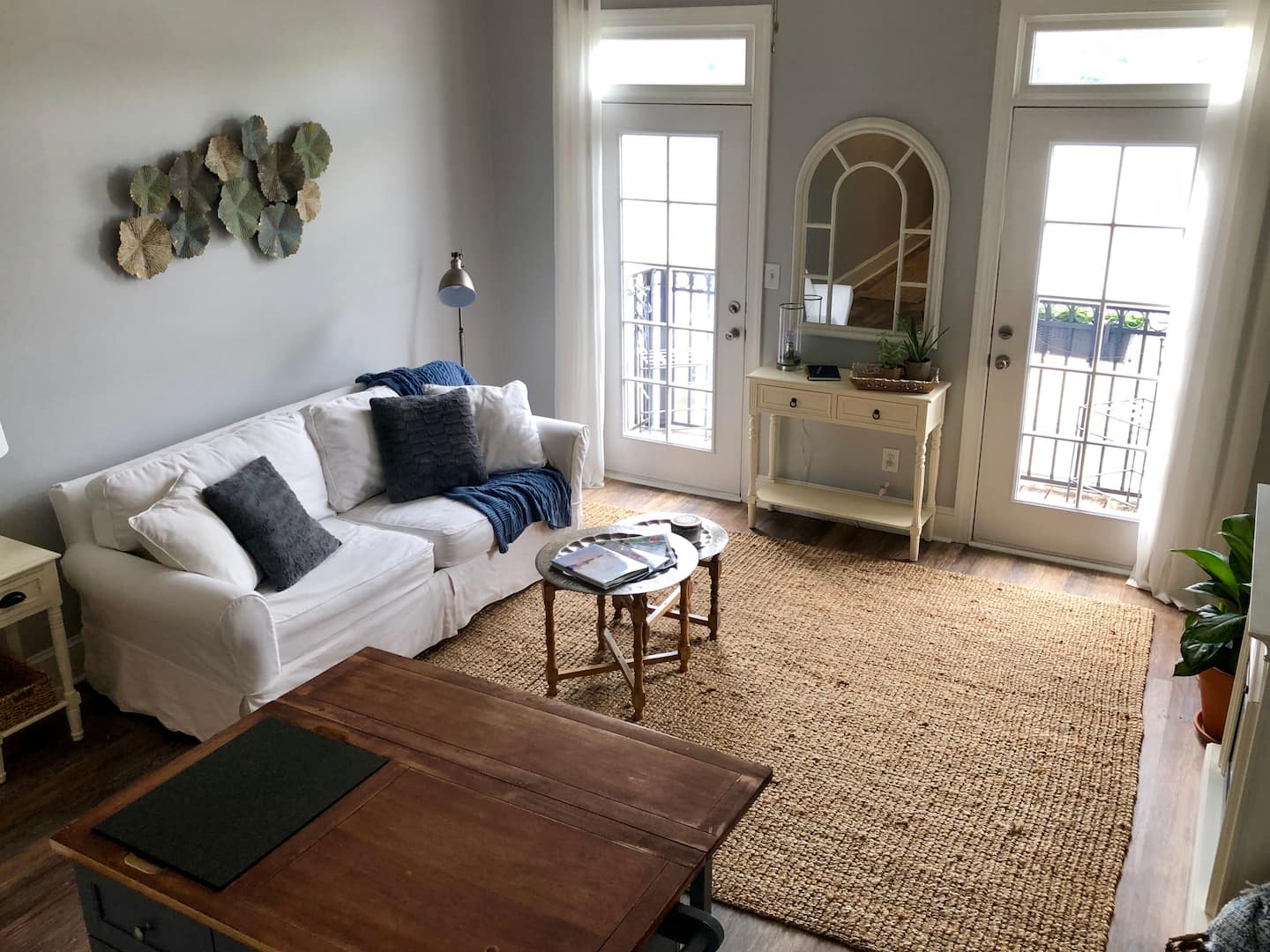 Bright living room with a white sofa and doors leading to the balcony